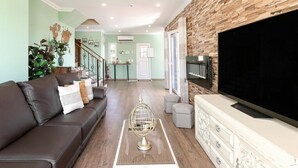 Un salon avec un canapé, une table basse, un téléviseur et une cheminée.