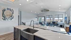 A modern kitchen with a large island, built-in appliances, and a dining area with a view.