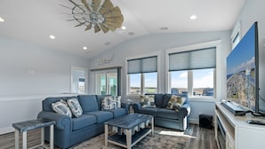 A modern living room with two sofas, a coffee table, and a TV.