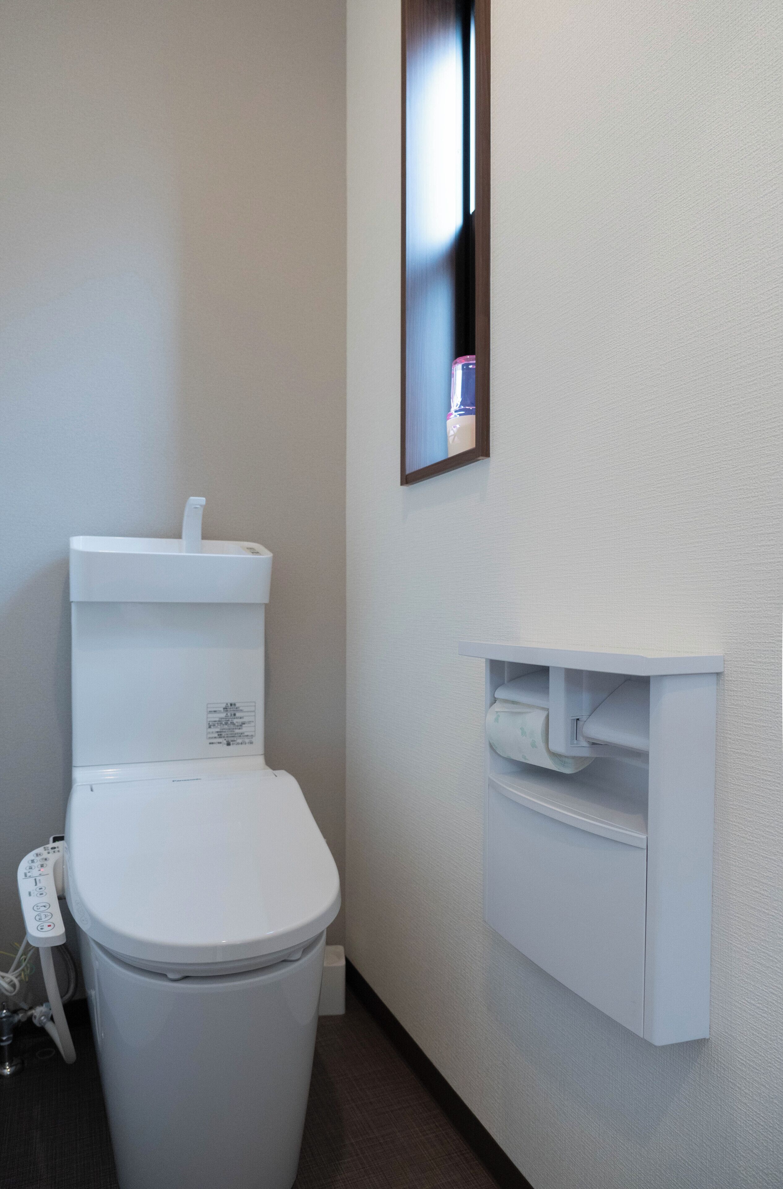 Un baño moderno con inodoro, lavamanos empotrado y espejo.