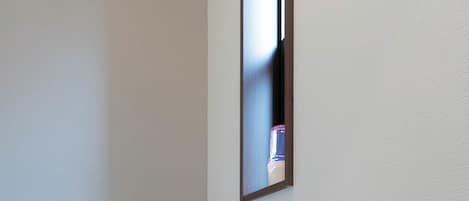 Un baño moderno con inodoro, lavamanos empotrado y espejo.