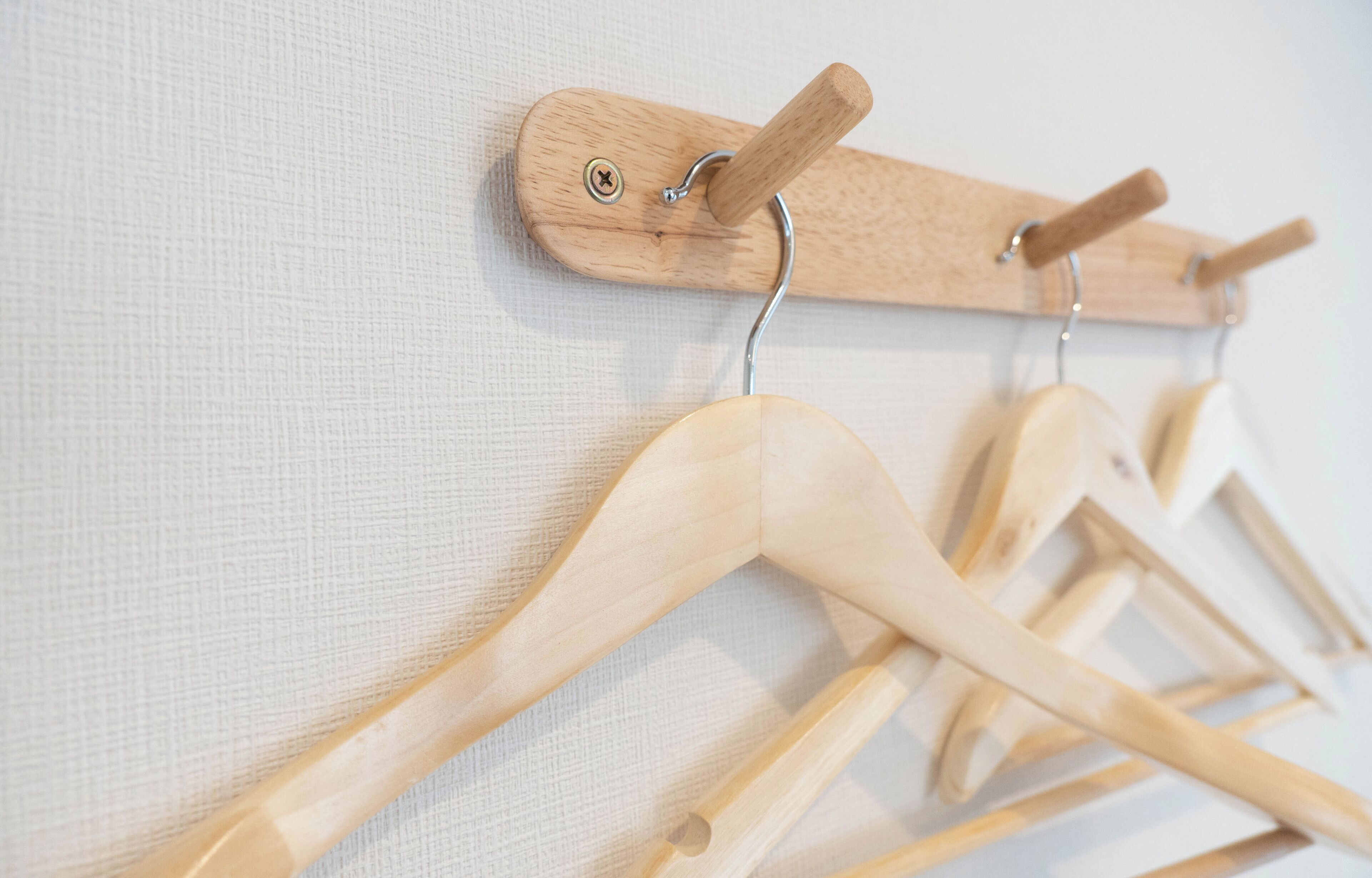 Un perchero de madera con varios ganchos de madera.