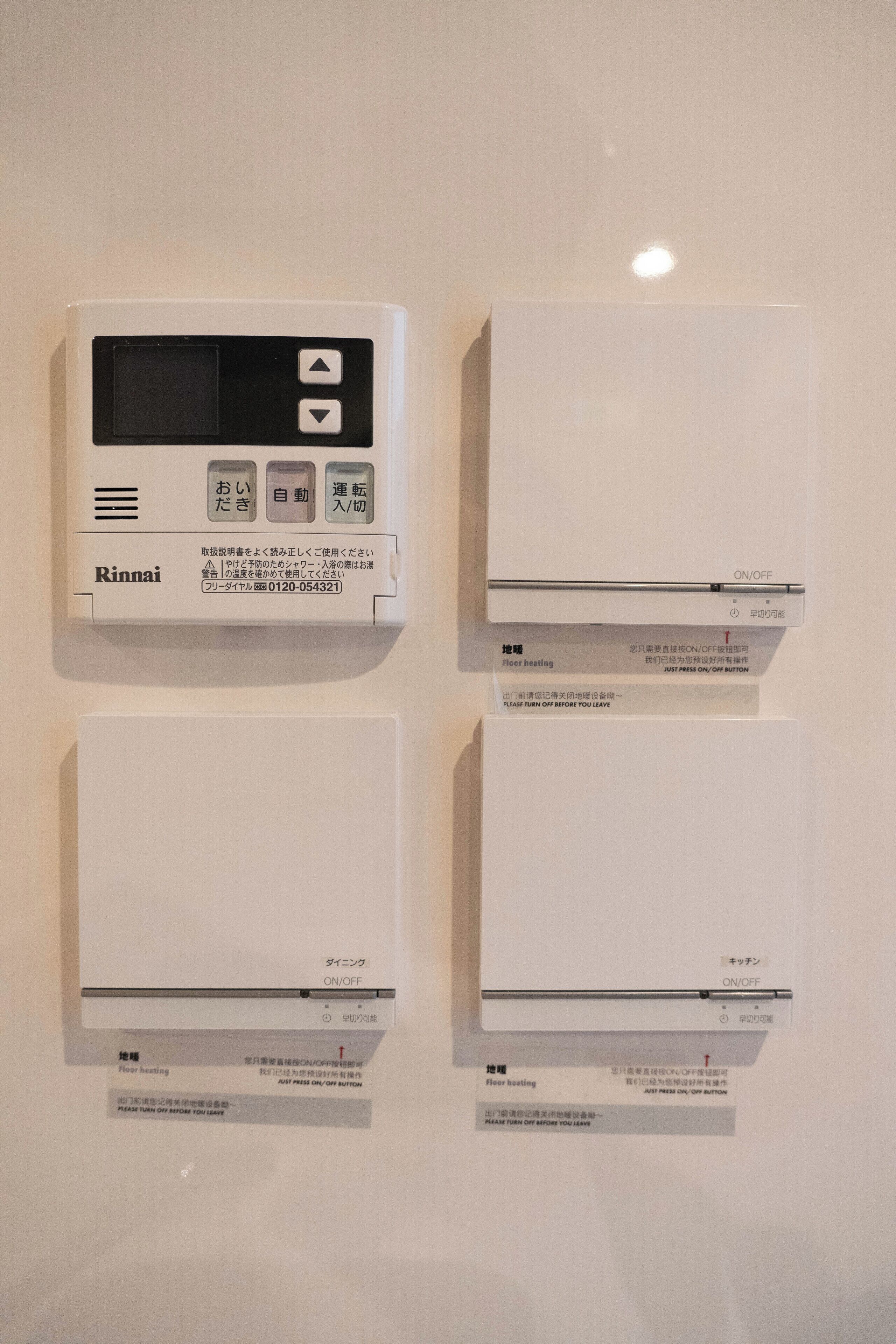 Vier bedieningselementen voor de thermostaat met Japanse tekst, waarschijnlijk voor de instelling van de temperatuur.