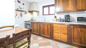 Une cuisine avec des meubles de rangement en bois, une cuisinière, un four à micro-ondes et un évier.
