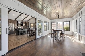 Een ruime keuken met moderne apparatuur en een eethoek met een grote tafel en stoelen.