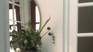 Een hoek van een kamer met een houten tafel, een potplant, een groene kom en een rieten mand.
