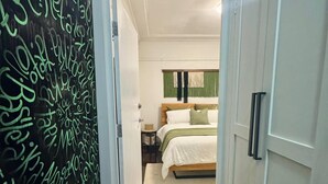 Een slaapkamer met een bed, nachtkastje en een bijpassend tafeltje.