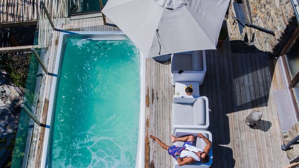 A rooftop pool with two lounge chairs and a large umbrella. - Mountain house - Mountain Hostel Tarter (El Tarter)