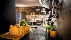 A modern kitchen with a stone wall, stainless steel appliances, and a wooden counter. - Mountain house - Mountain Hostel Tarter (El Tarter)