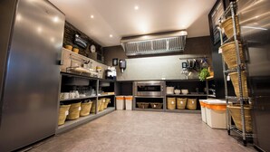 A modern kitchen with stainless steel appliances, wicker baskets, and a central island. - Mountain house - Mountain Hostel Tarter (El Tarter)