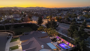 A residential area with houses, a swimming pool, and a well-lit patio area.