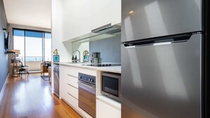 A modern kitchen with stainless steel appliances, a dishwasher, and a built-in oven. - Aquabelle Four on Rye Beach (Rye)