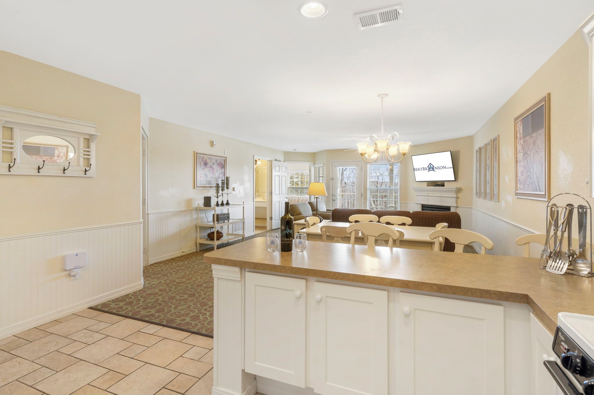 A spacious kitchen with a central island, a dining area with chairs, and a living room with a sofa.