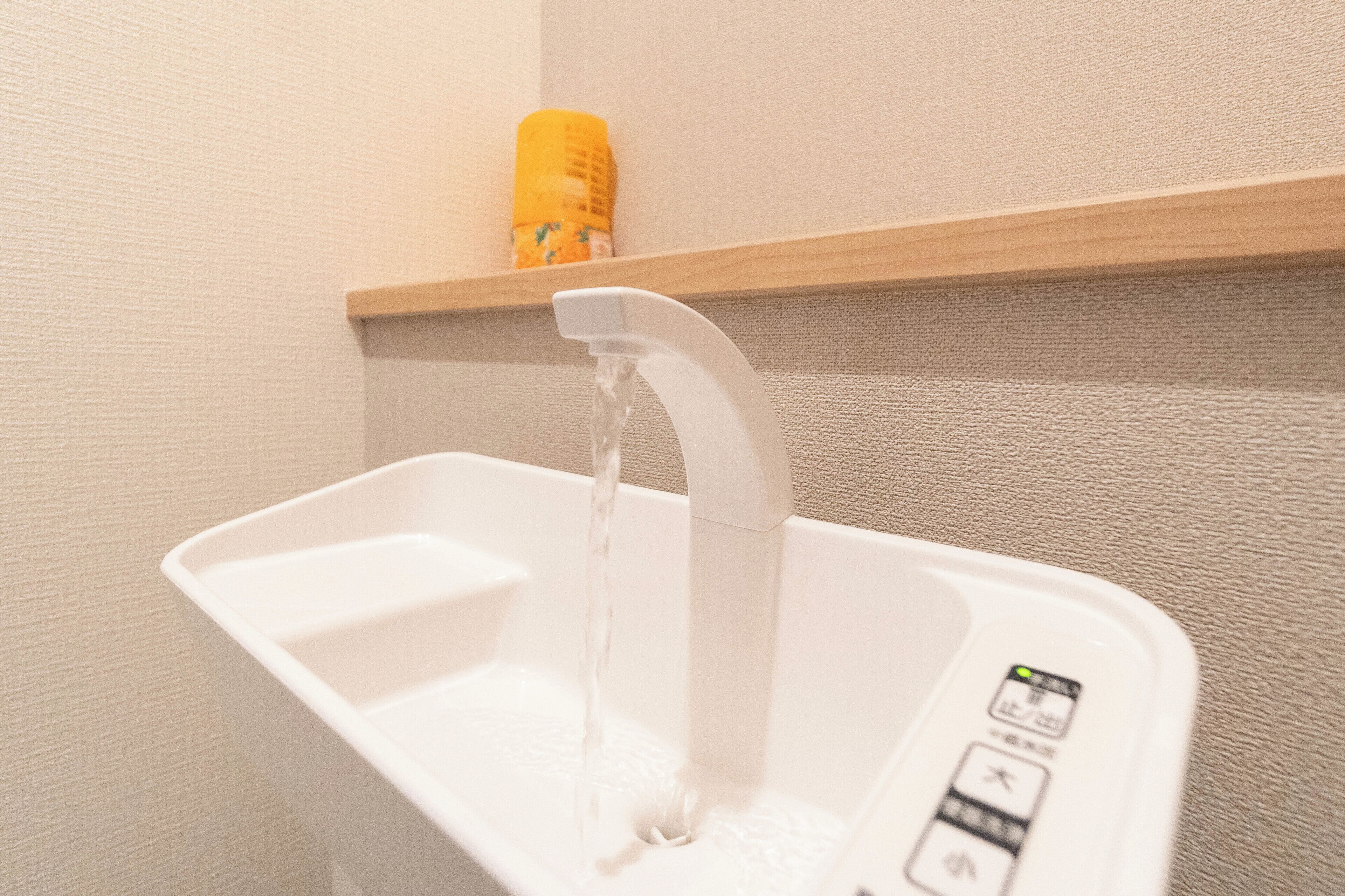 A white sink with a modern faucet and control buttons.