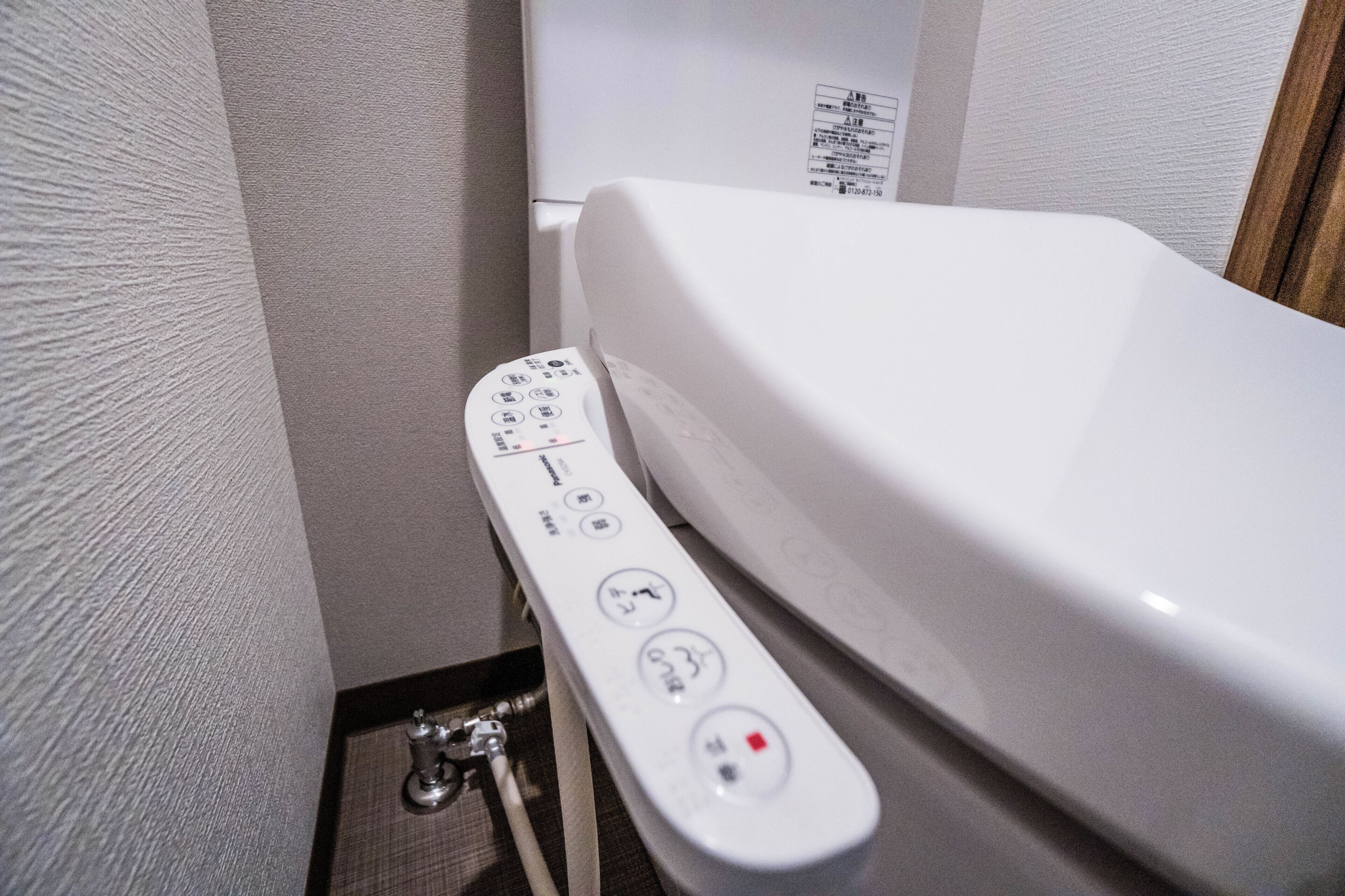 A white bathtub with a control panel featuring multiple buttons and a red light indicator.