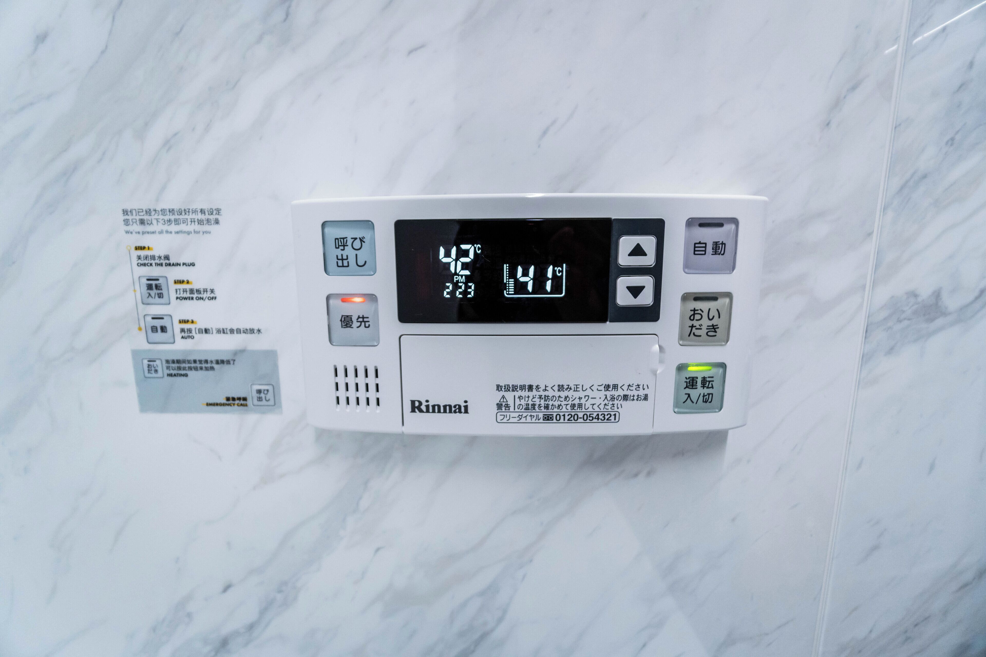 A Rinnai water heater with a digital display, control buttons, and instructions in Japanese.