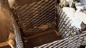 A metal mesh structure with a metal frame, surrounded by a pile of rocks. - Alaska Native Steam Bath w/Power and Water for RV, free wifi (Wasilla)