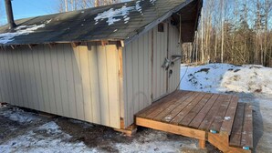 A small wooden shed with a sloped roof and a wooden ramp leading to the entrance. - Alaska Native Steam Bath w/Power and Water for RV, free wifi (Wasilla)