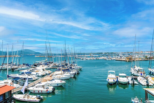 Un port de plaisance où de nombreux bateaux sont amarrés, l’eau est calme et le ciel est dégagé.