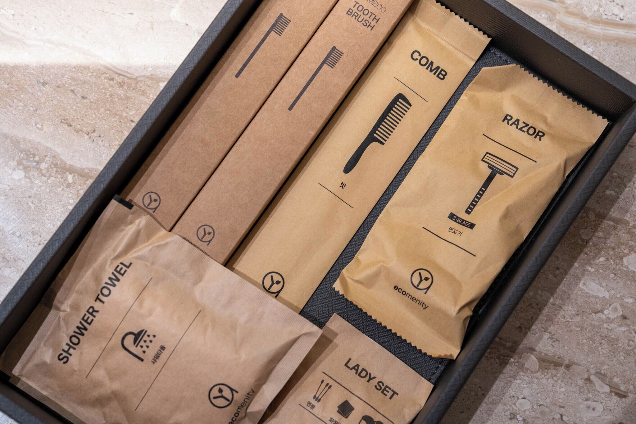 Una caja con artículos de aseo personal como maquinilla de afeitar, peine y toalla de ducha.