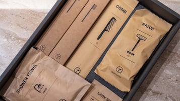 Una caja con artículos de aseo personal como maquinilla de afeitar, peine y toalla de ducha.