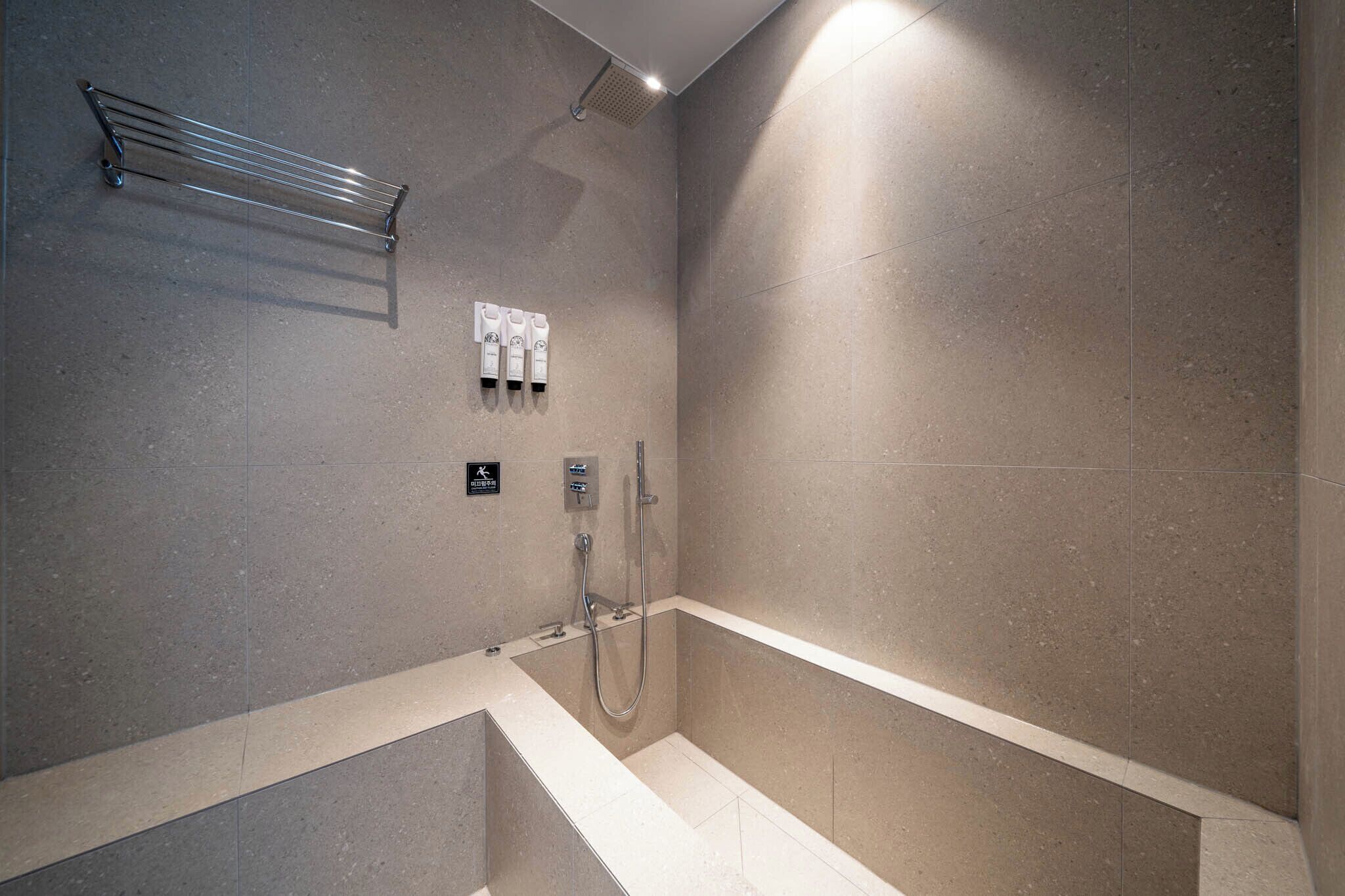 A modern bathroom with a bathtub, a shower, and a towel rack.