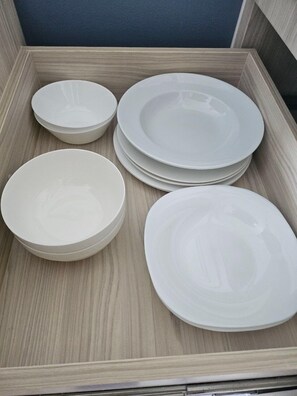 A set of white plates and bowls in a wooden tray. - Residence Seven Sea Cote Na Chom Thian (Pattaya)