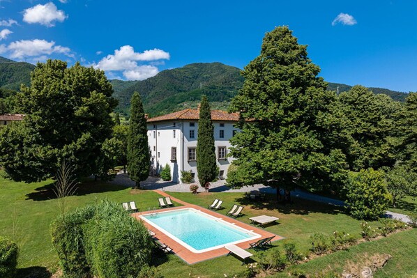 Relax by the large pool surrounded by a lush lawn and picturesque hills.