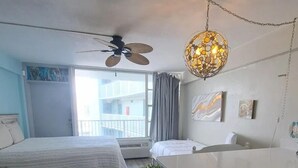 Un dormitorio moderno con cama, escritorio y ventilador de techo.