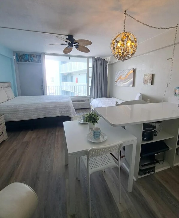 Un dormitorio moderno con cama, escritorio y ventilador de techo.