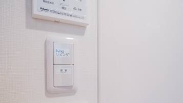 A thermostat and a control panel on a wall.