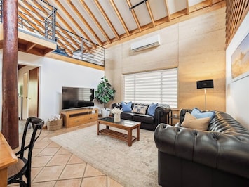 Soaring ceilings, Chesterfield sofas, and a smart TV make this living space the perfect spot to unwind