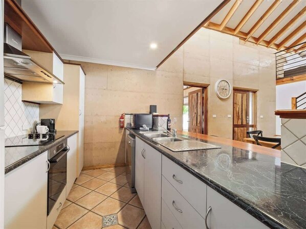 A kitchen with a central island, a stove, and a sink.