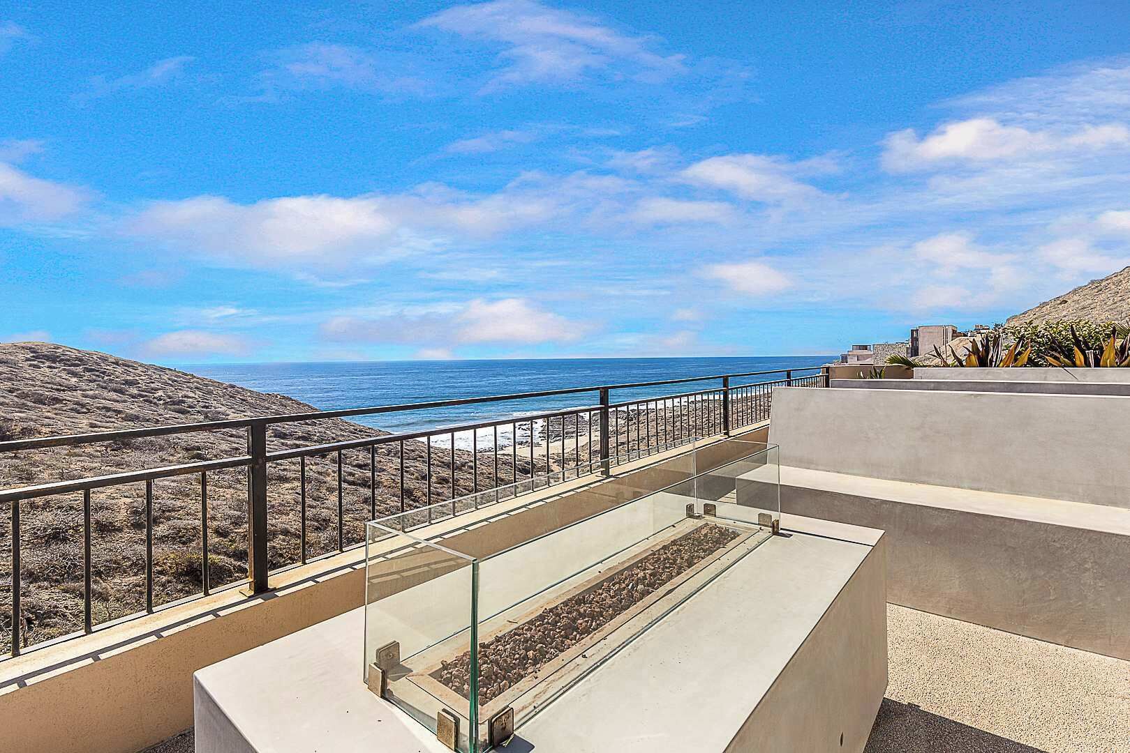 Varanda com vista clara para a praia e o oceano.