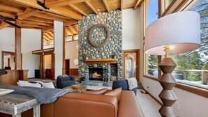 Una sala de estar acogedora con chimenea de piedra, sofá de cuero y una lámpara.