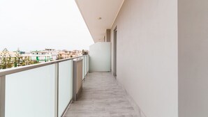 Een smal balkon met uitzicht op gebouwen in de verte.