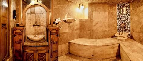 Une salle de bain de style traditionnel avec un lavabo en bois, une baignoire et un mur décoratif.