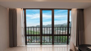A modern room with a large window, a round table, and a chair. - Guangzhou Nansha Meihao Lizhi Hotel (Guangzhou)