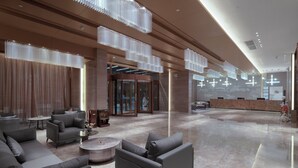 A spacious lobby with modern furniture, a reception desk, and a glass entrance. - Guangzhou Nansha Meihao Lizhi Hotel (Guangzhou)