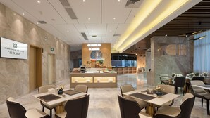 A modern hotel lobby with a reception desk, seating area, and a bar. - Guangzhou Nansha Meihao Lizhi Hotel (Guangzhou)
