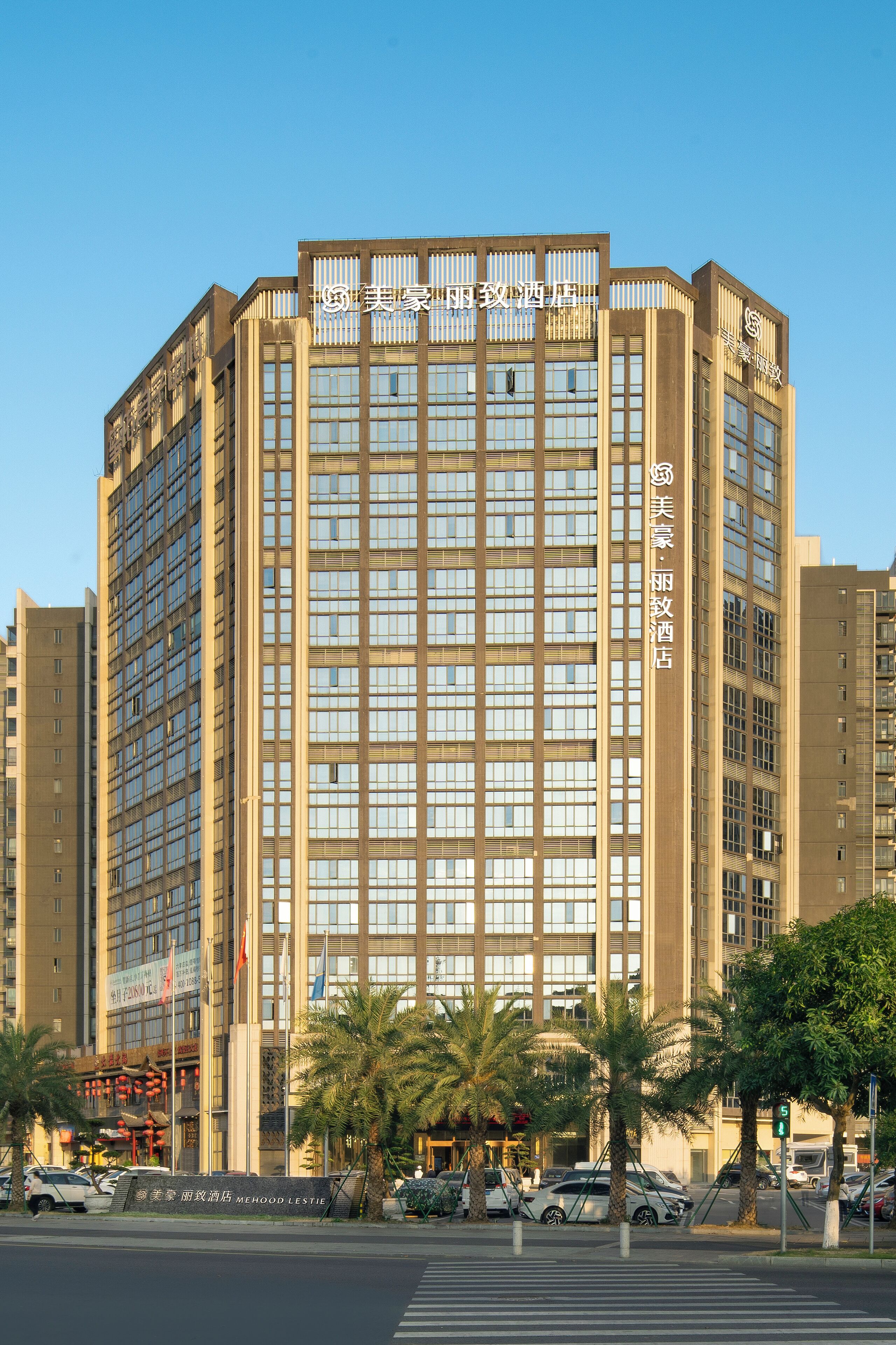 A multi-story hotel with a modern facade, featuring a series of windows and a prominent entrance.