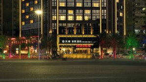 A modern hotel building with illuminated signage, multiple floors, and a prominent entrance. - Guangzhou Nansha Meihao Lizhi Hotel (Guangzhou)