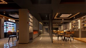 Un intérieur moderne comprenant un comptoir de boissons, un espace salon et des étagères remplies de divers articles.