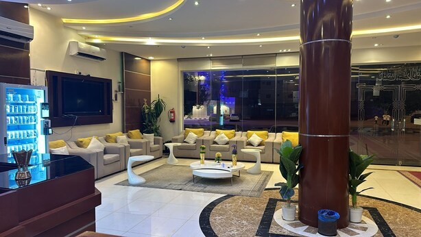 A modern lobby with sofas, a coffee table, and a large pillar. - Luluat Althuraya Serviced Apartments (Riyadh)
