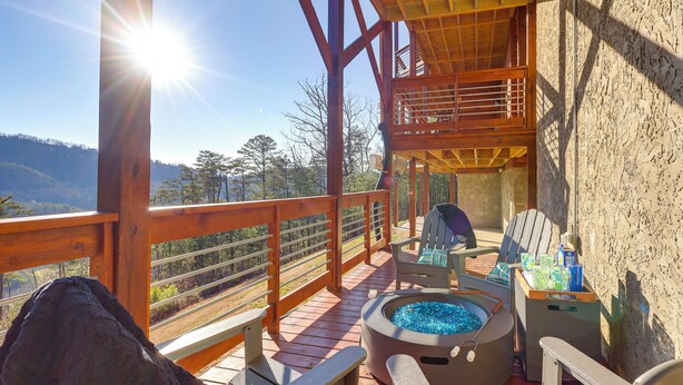 A wooden deck with a hot tub, seating area, and a view of the mountains. - Majestic Mountain Views: Sevierville Escape! (Sevierville)