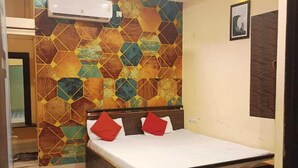 Une chambre à coucher avec un lit, un ventilateur de plafond et un climatiseur fixé au mur.