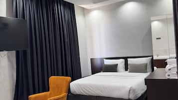 Una habitación de hotel moderna con una cama, un televisor, un escritorio y una silla.