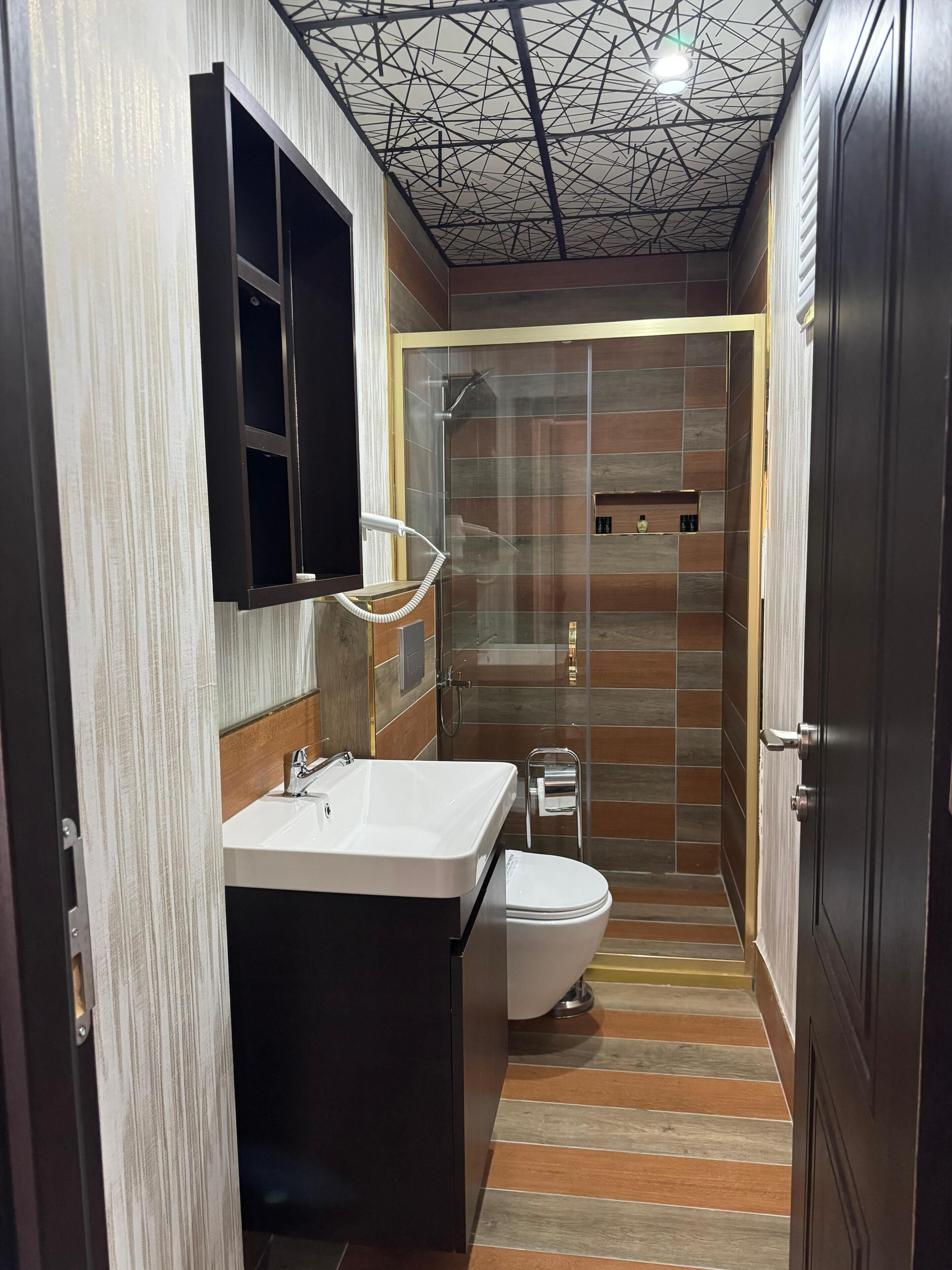A modern bathroom with a shower, toilet, and vanity.