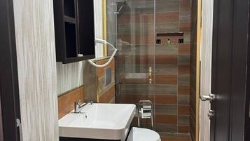 A modern bathroom with a shower, toilet, and vanity.
