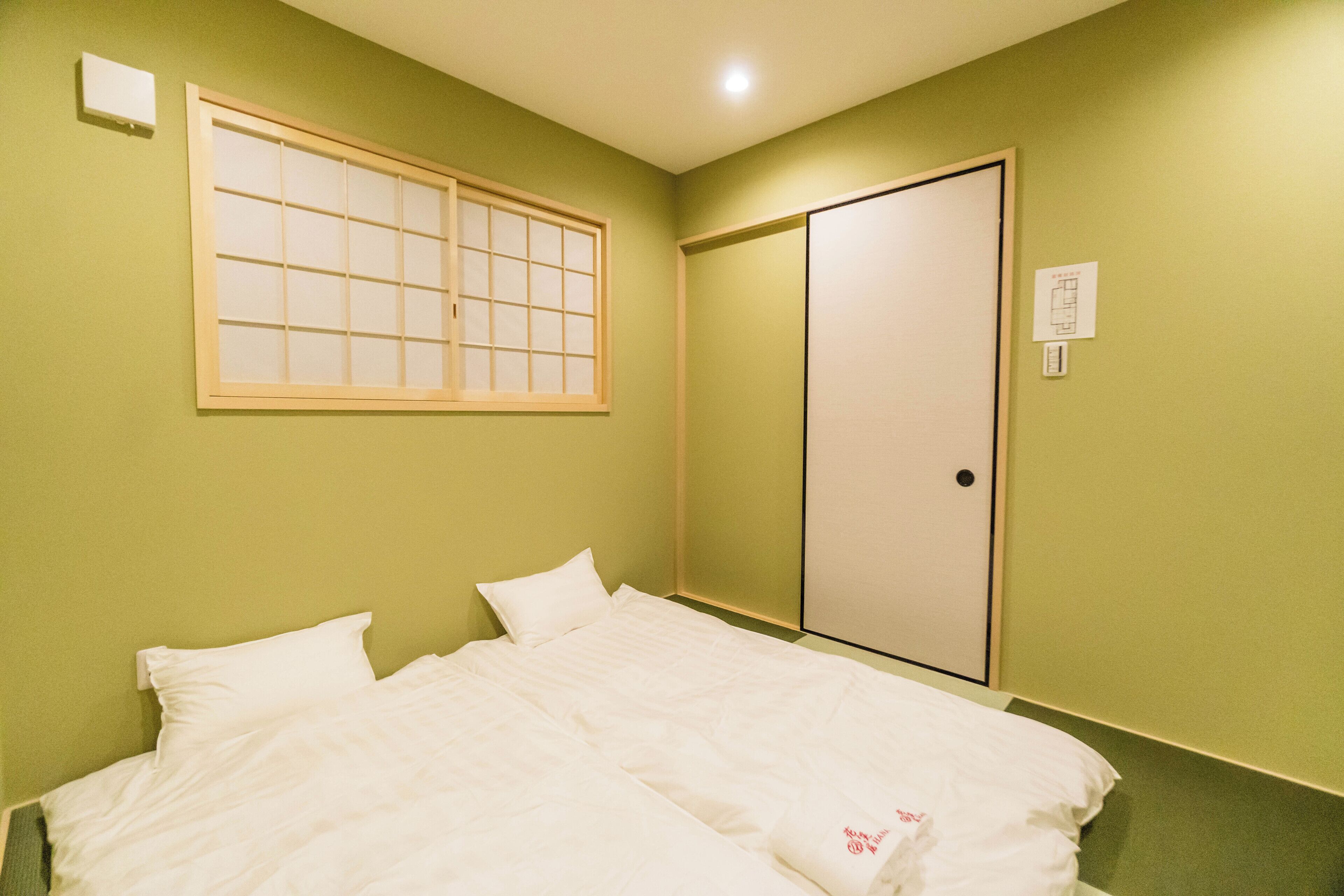 A room with a bed, a window, and a door.